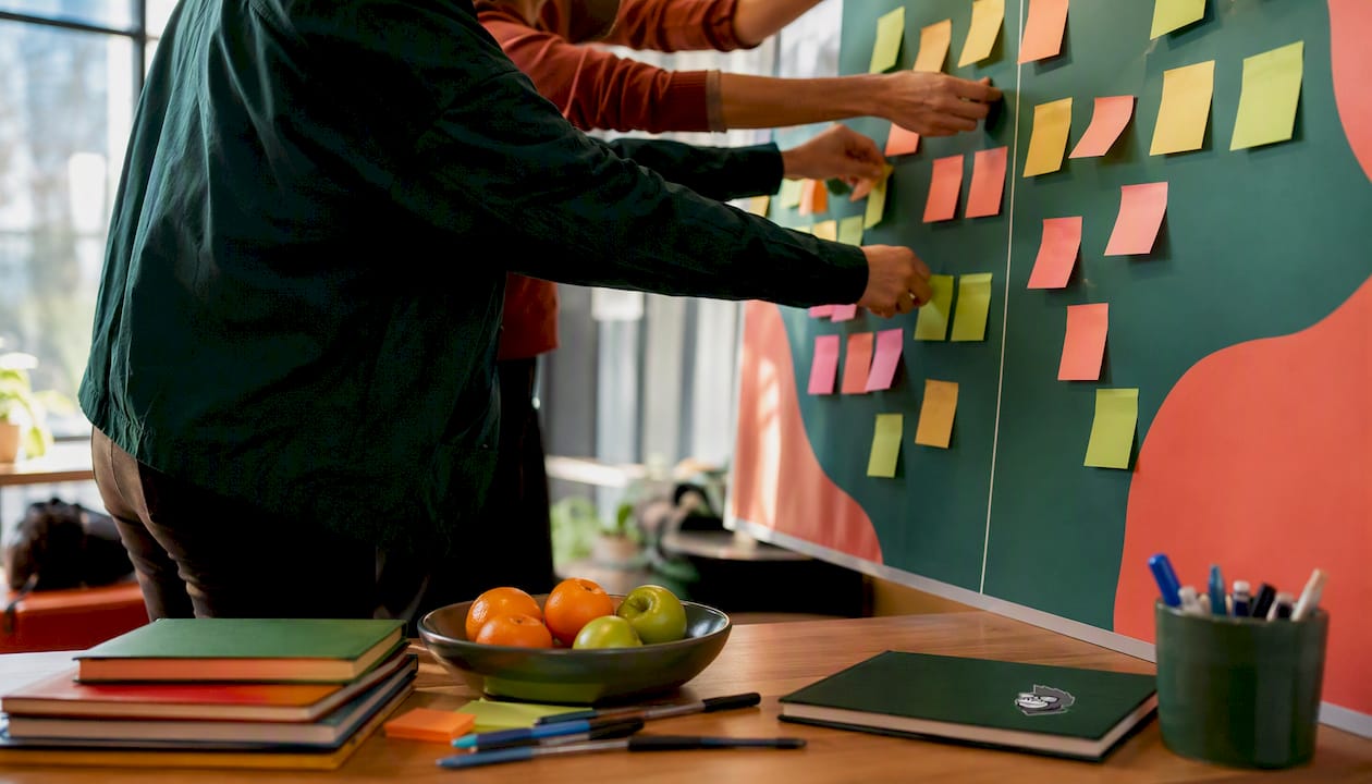 Hands arranging sticky notes in analysis session