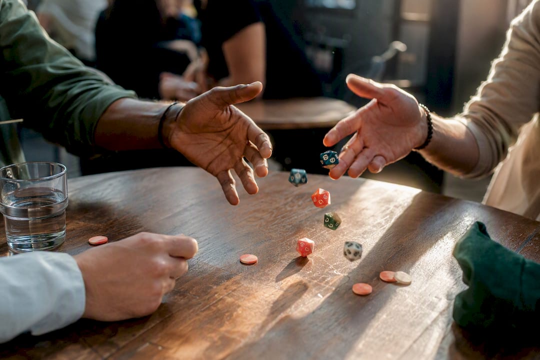 Hands rolling colorful dice during icebreaker game