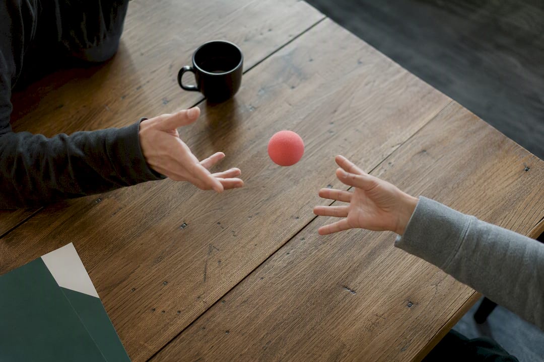 Hands passing coral foam ball in team game